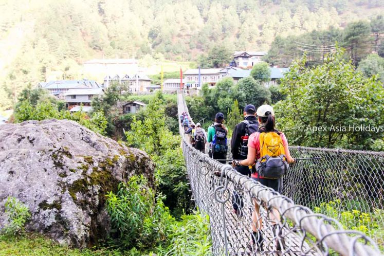Trekkers and trekking crews crossing a suspension bridge along the Everest Trekking Route